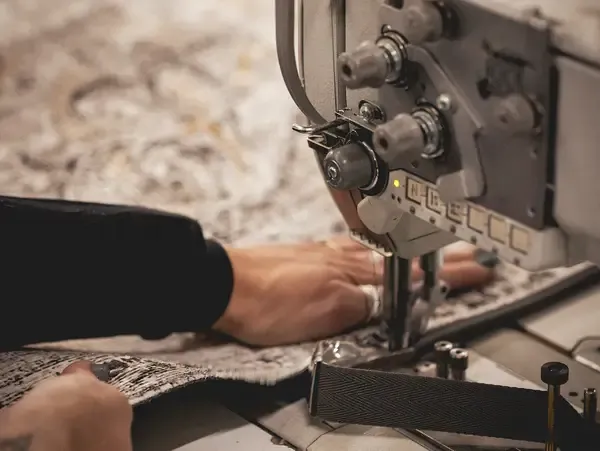 Someone stitching a washable rug on a sewing machine
