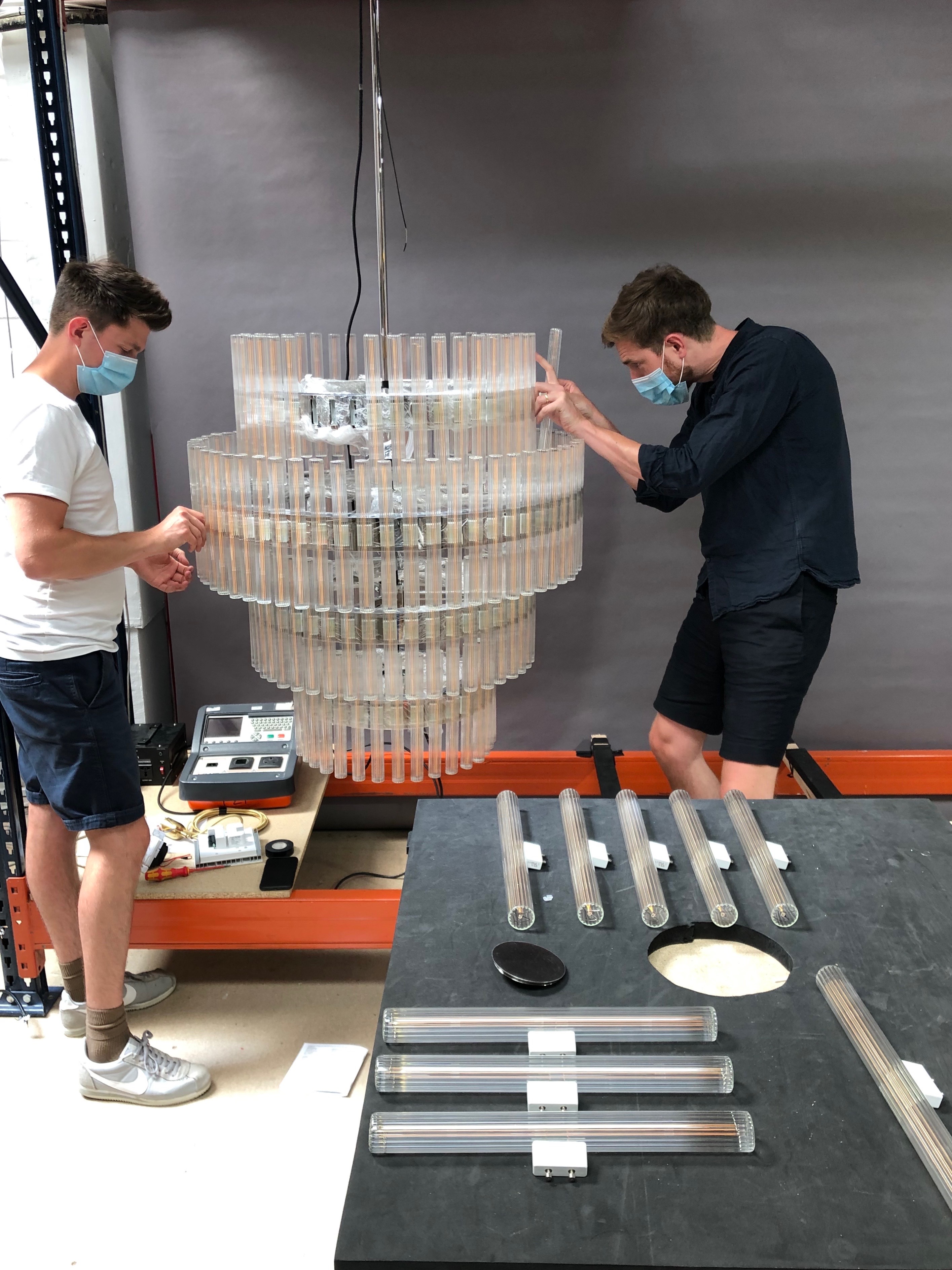 Behind the scenes at Lee Broom HQ where the team assembles an Aurora 3 Tier Chandelier made from handblown bulbs with LED lamps that emit a soft glow of light around each ring. Photo c/o Lee Broom. 