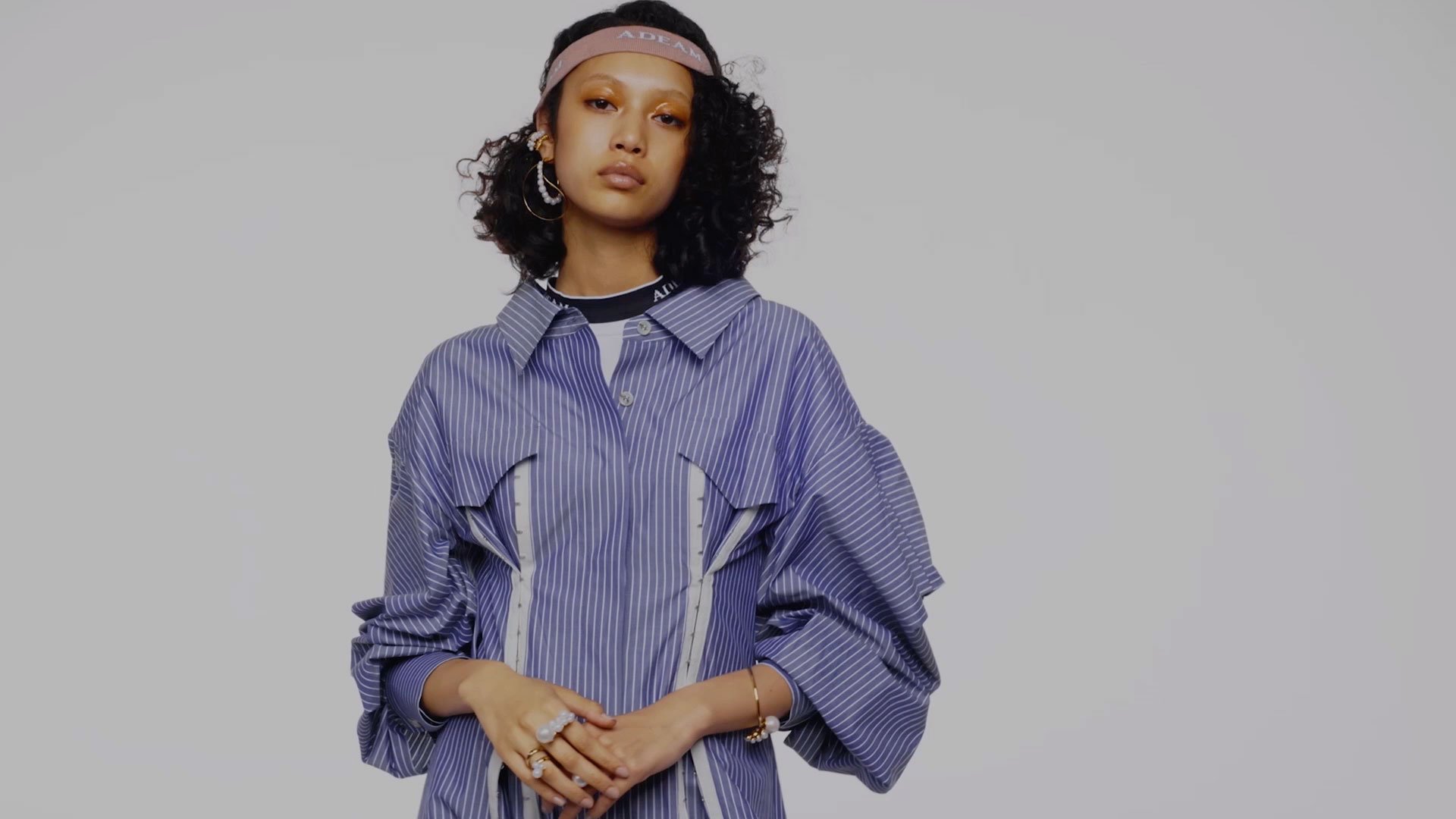 naomi osaka posing in a blue dress against a white wall