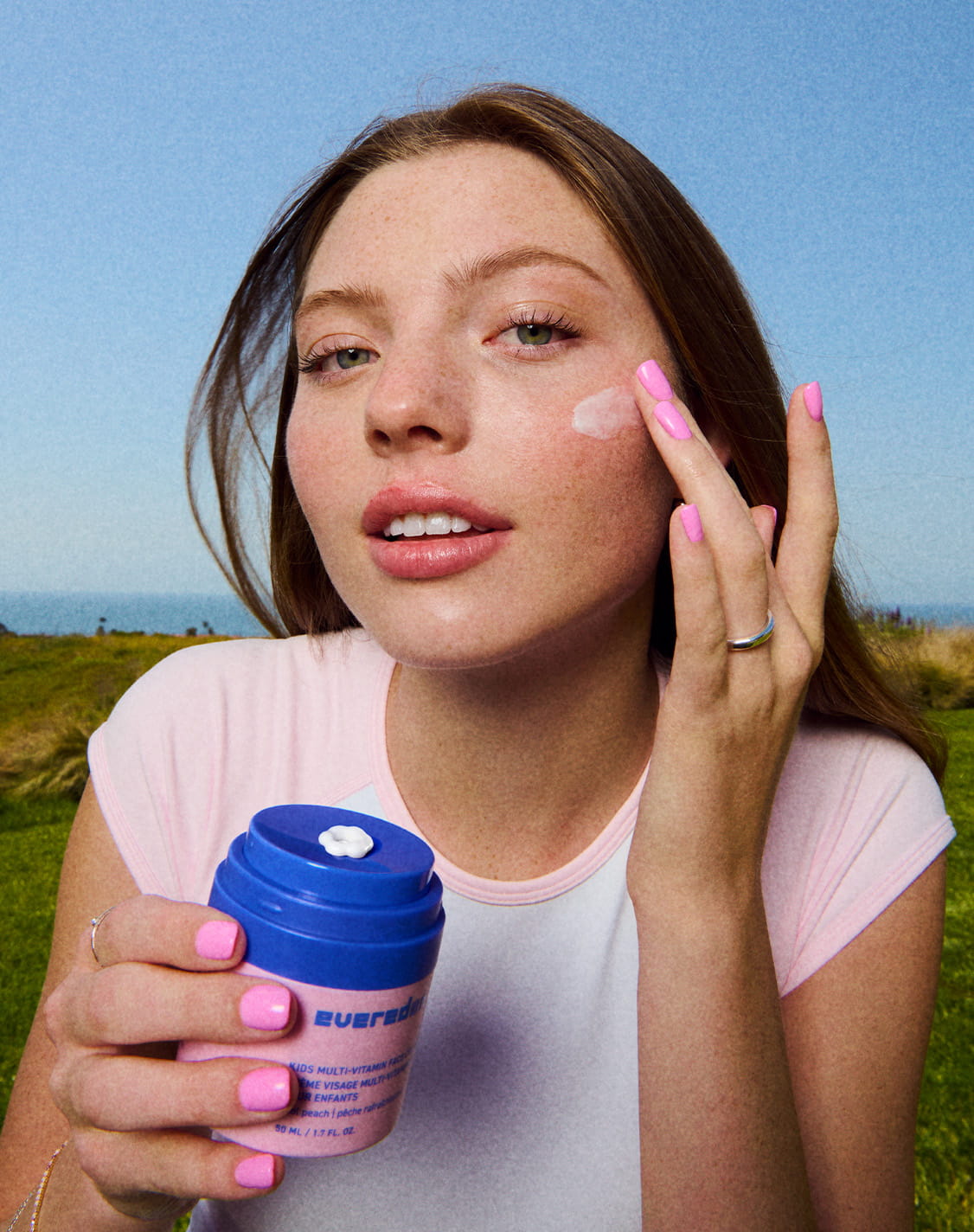 Model Applying Kids Multi-Vitamin Face Cream in Cool Peach