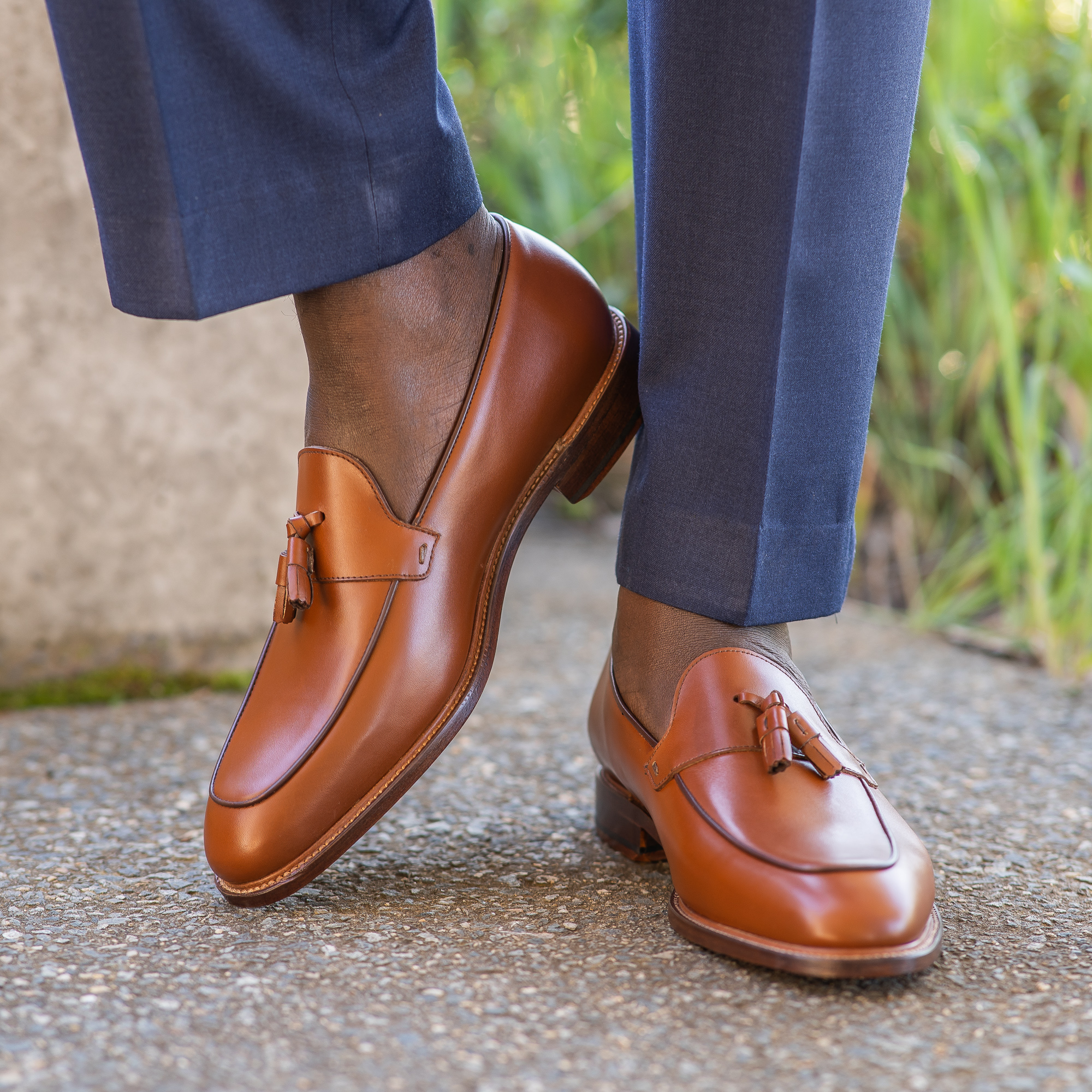 The Albert tassel men’s leather loafer with tassel in burgundy, paired with blue merino wool woven trousers