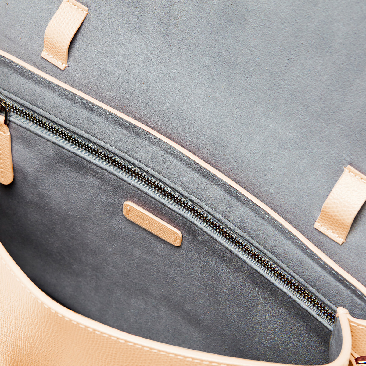 shoulder bag in light beige inside zipper pocket view.