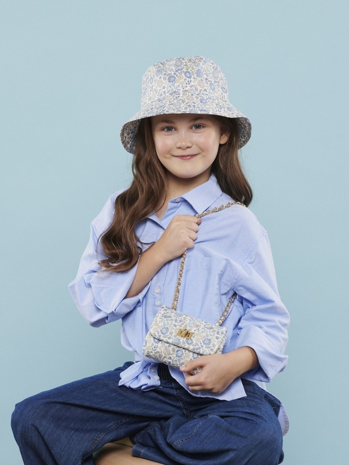 young girl wearing floral print bucket hat and matching purse