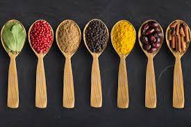 a row of wooden spoons with different spices