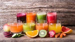a group of glasses of different colored drinks