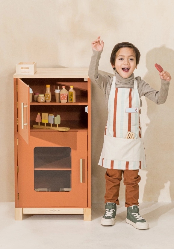 young boy playing with pretend kitchen set