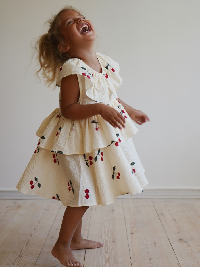 young girl twirling in cherry ruffle dress