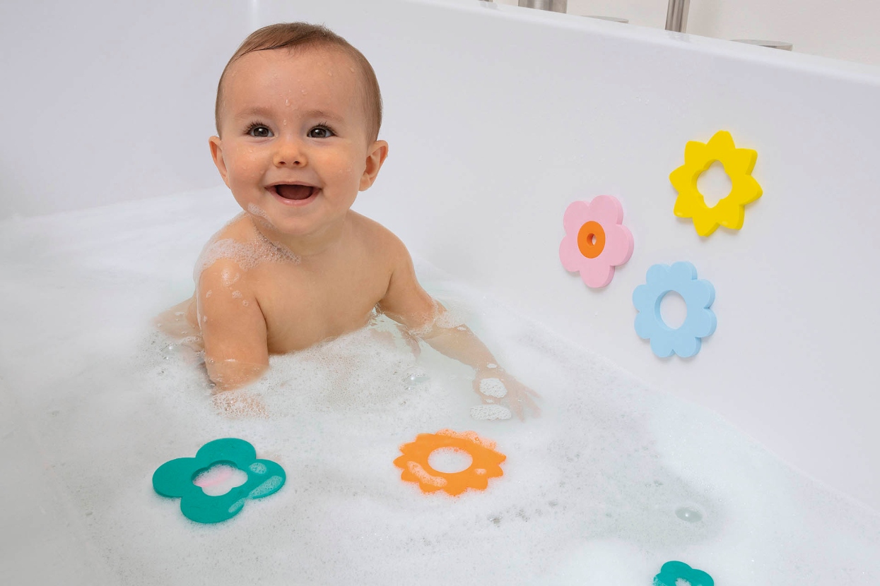 baby in bathtub playing with quut bath toys