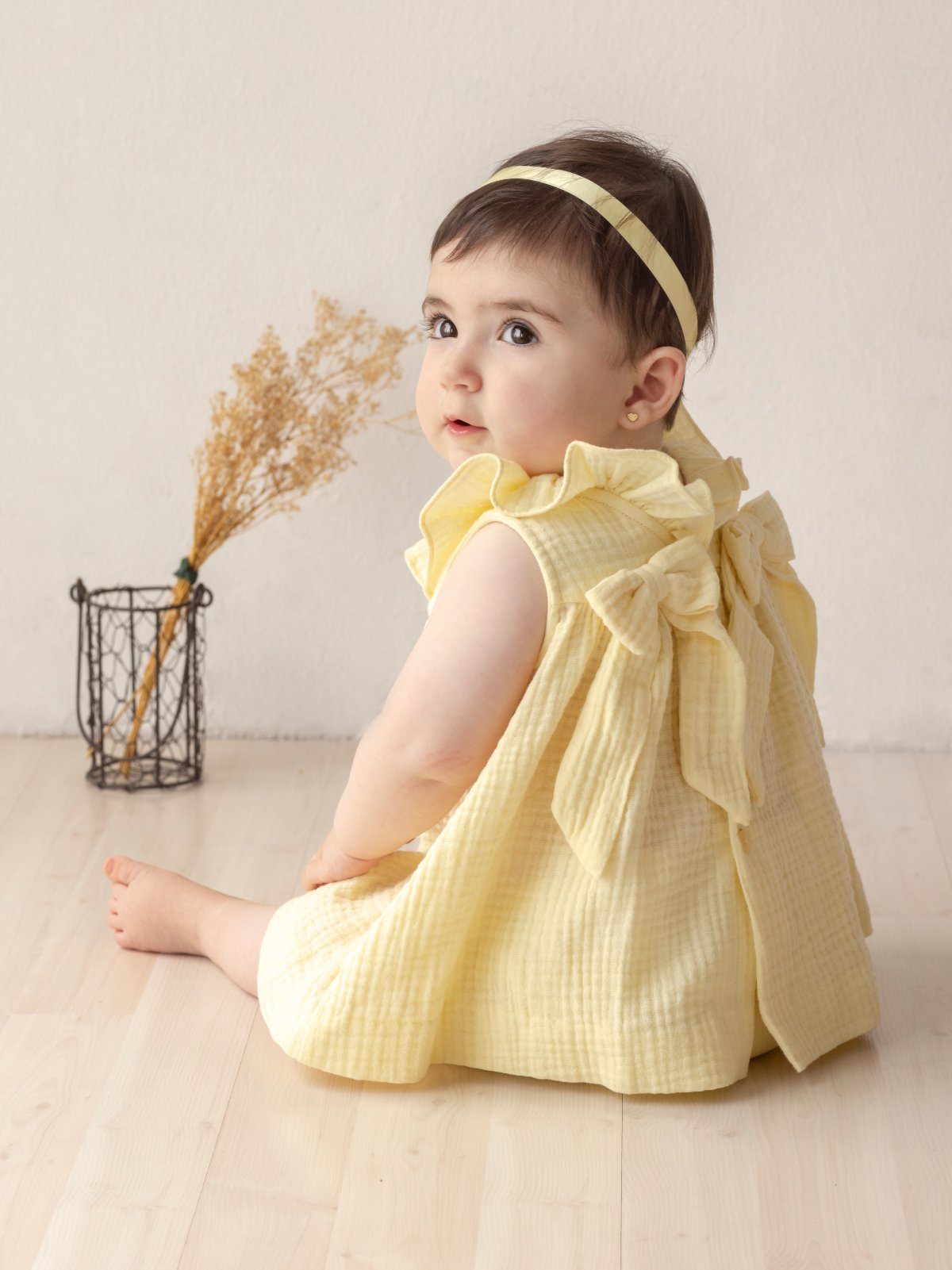 baby girl sitting wearing yellow dress