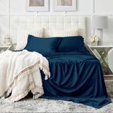 A pristine white bed with Cosy House Collection bedding.