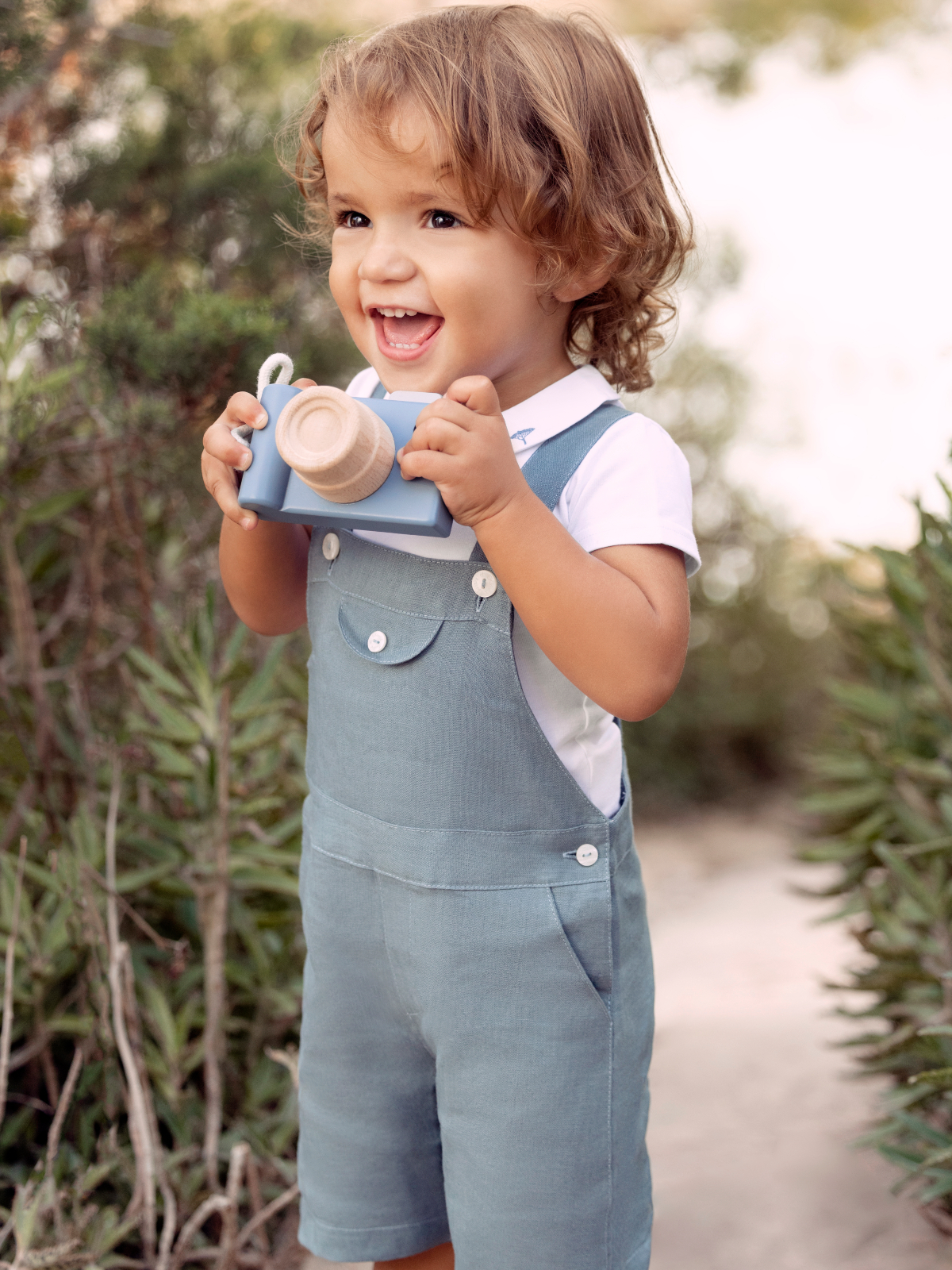 young boy wearing tartine et chocolat blue overalls