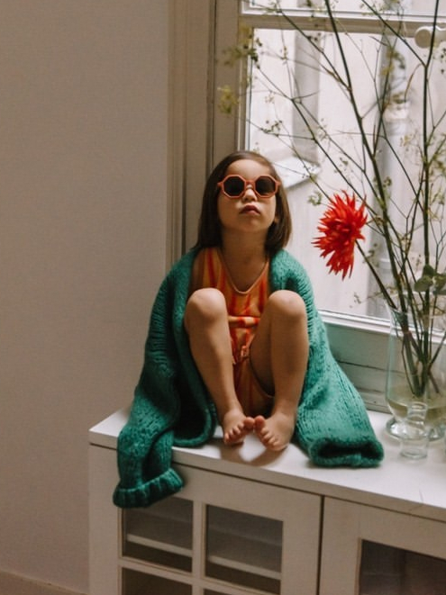 girl sitting in front of window wearing yeye sunglasses