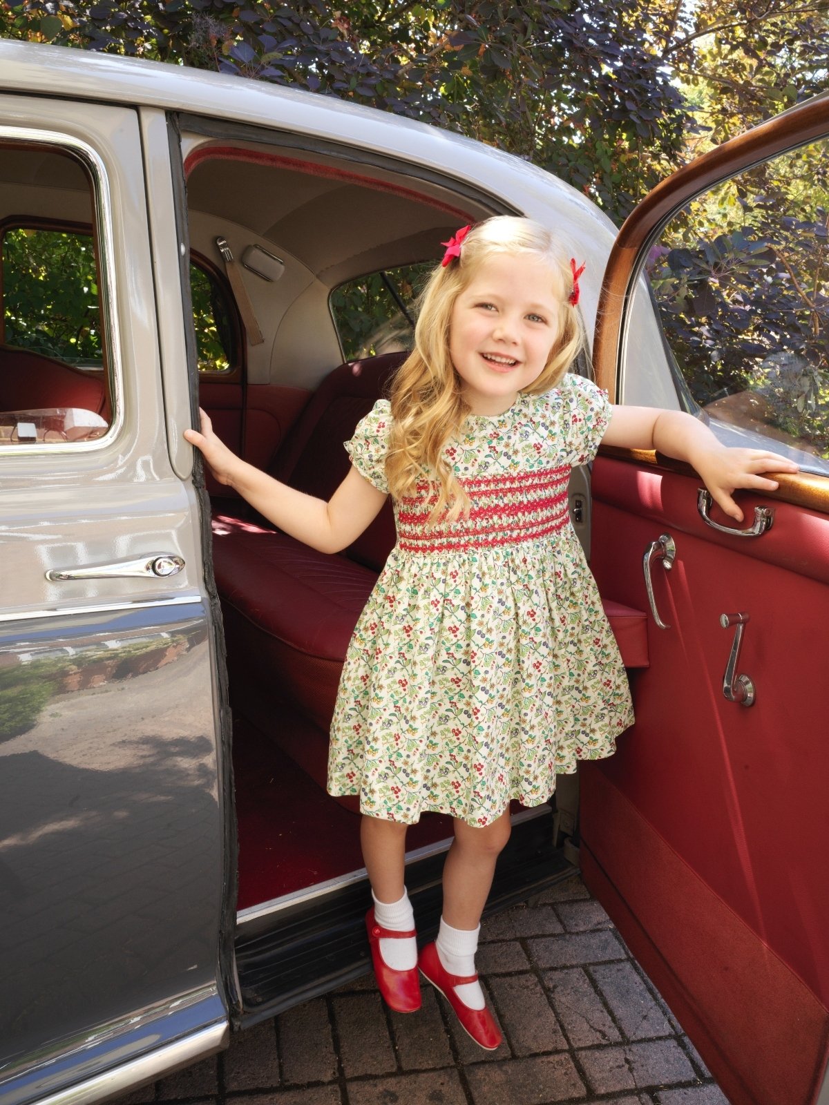 girl wearing red and green rachel riley dress