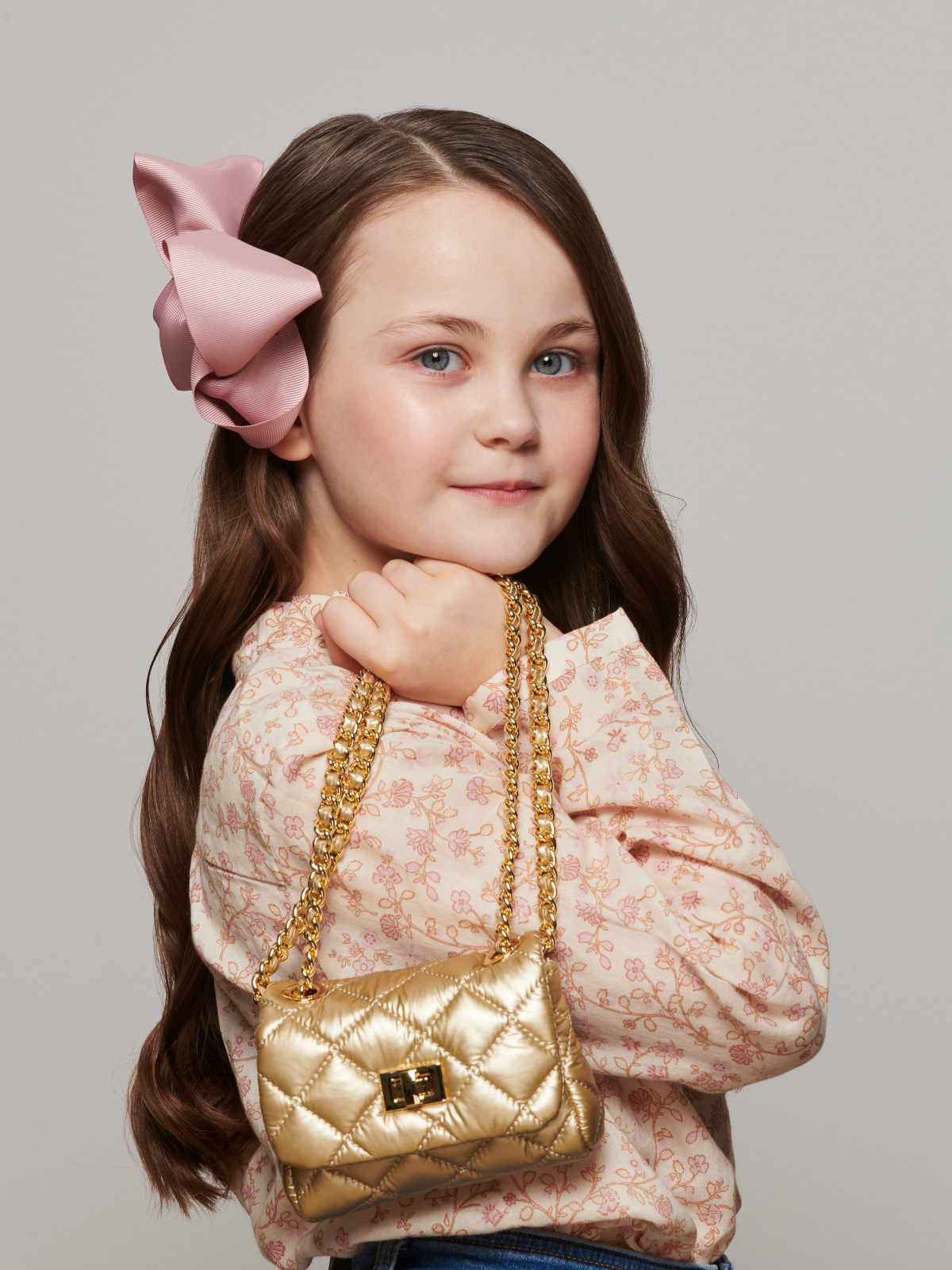 young girl holding gold purse over her shoulder