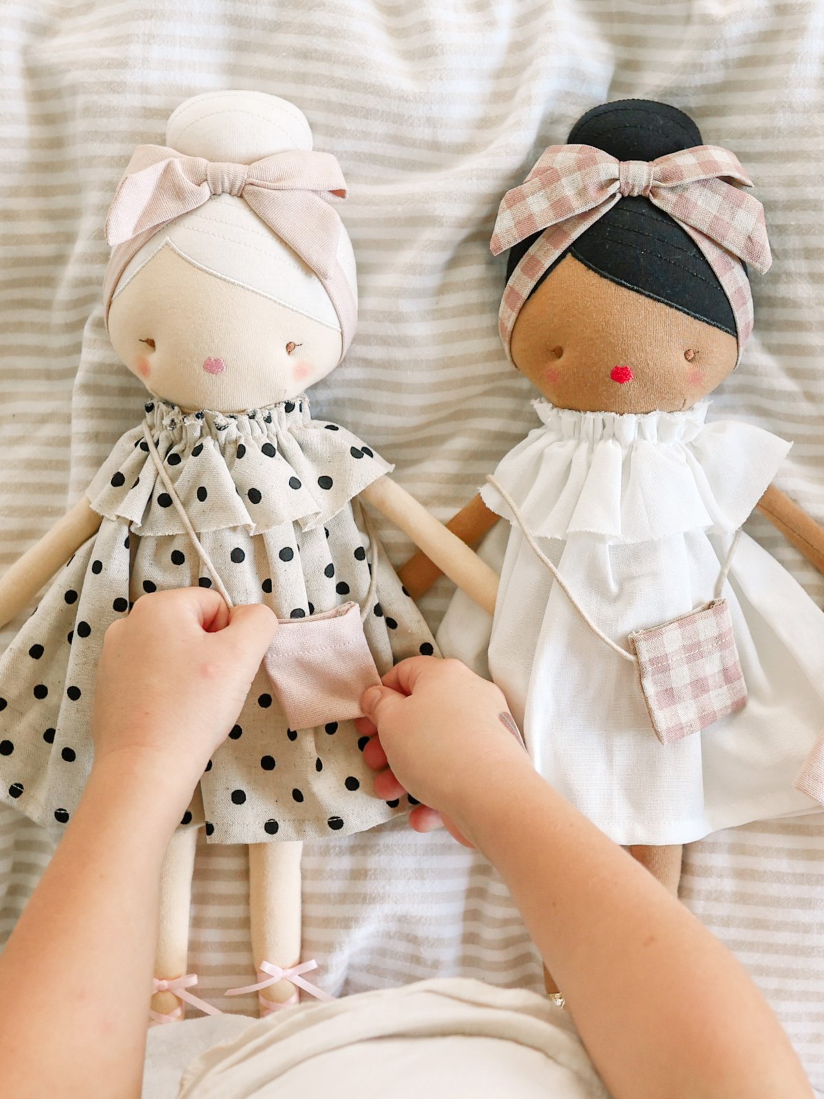 two dolls wearing dresses and mini purses