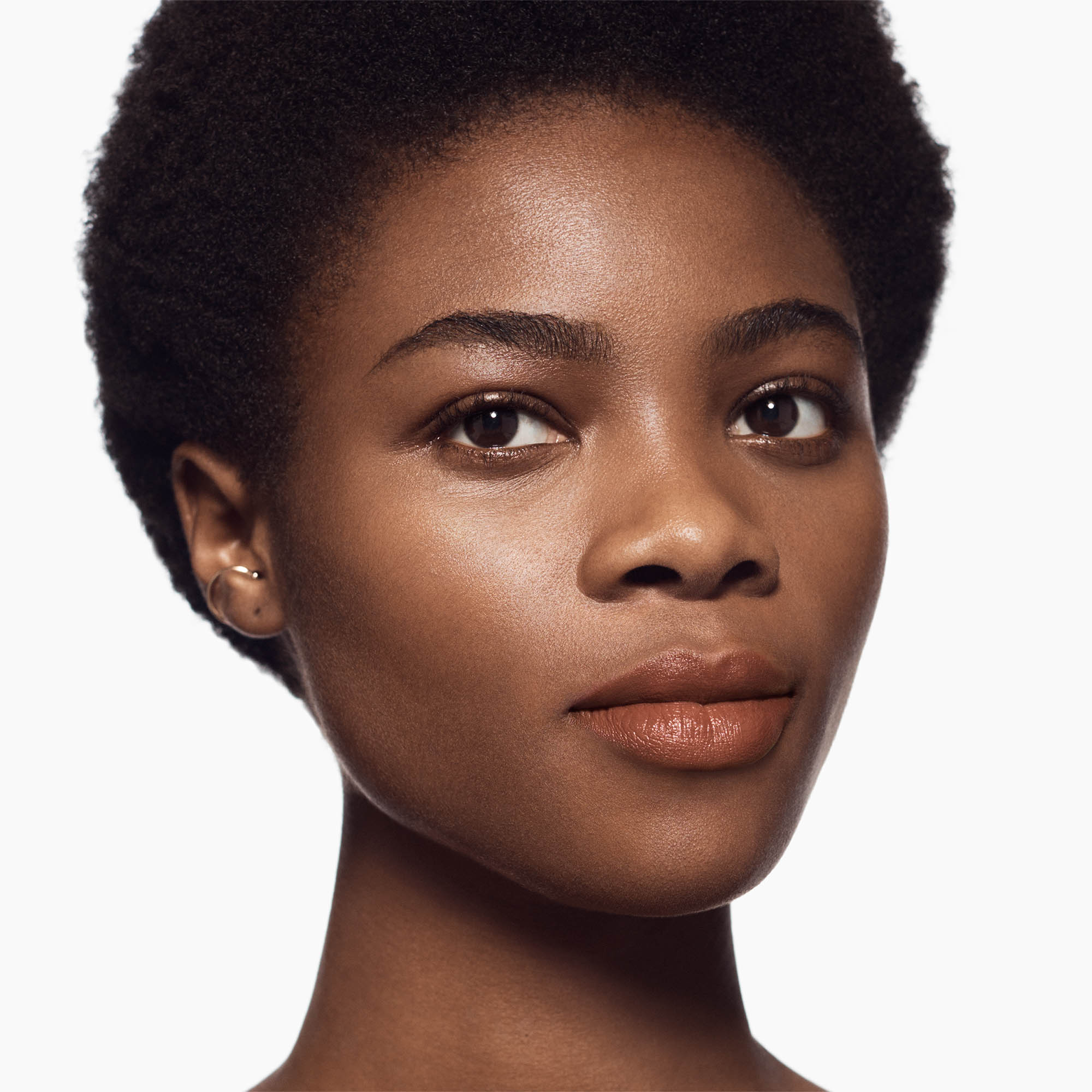 Image of deep skin tone model wearing the Satin Lip Color Rich Refillable Lipstick in shade Gravceful 1
