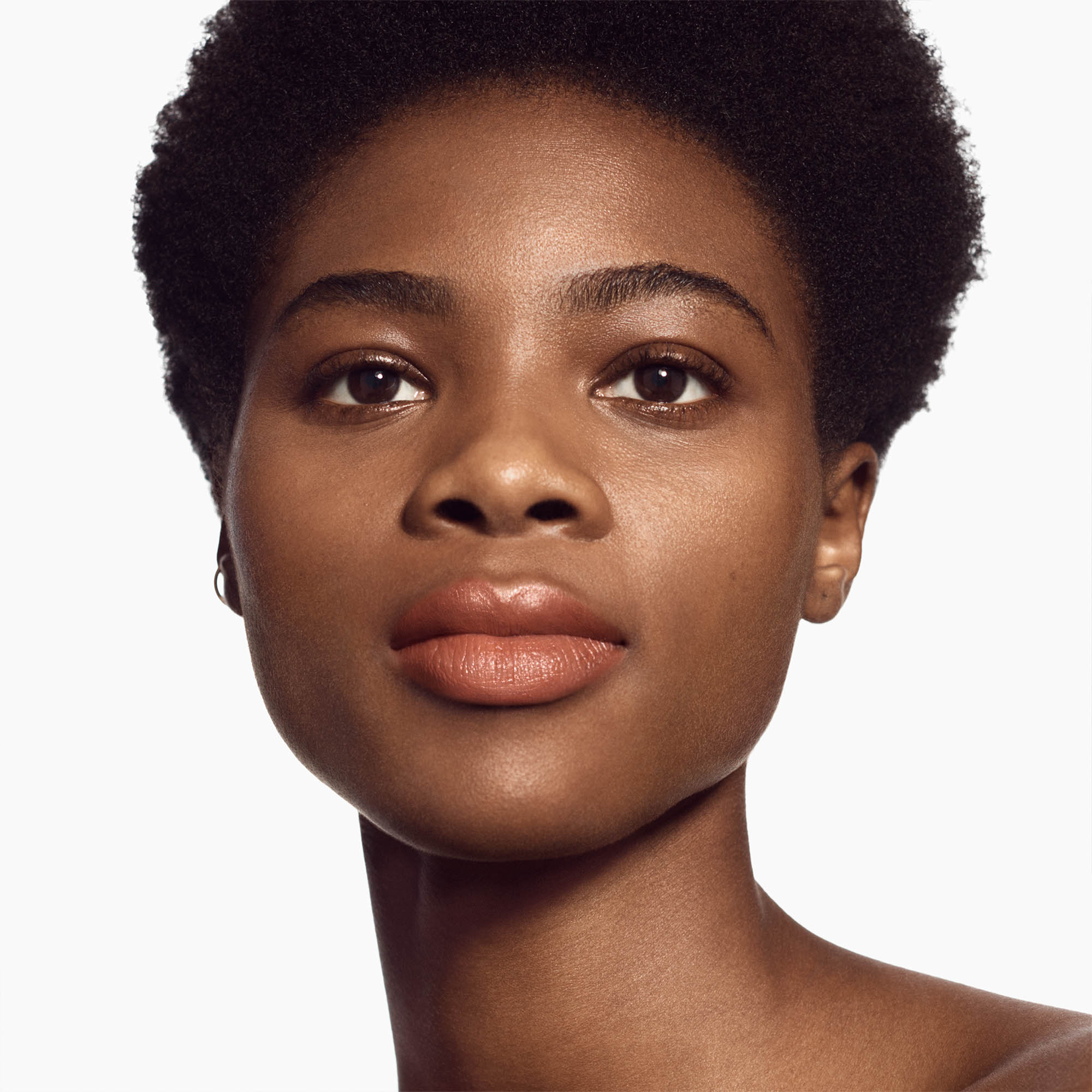Image of deep skin tone model wearing the Satin Lip Color Rich Refillable Lipstick in shade Hypnotic 1