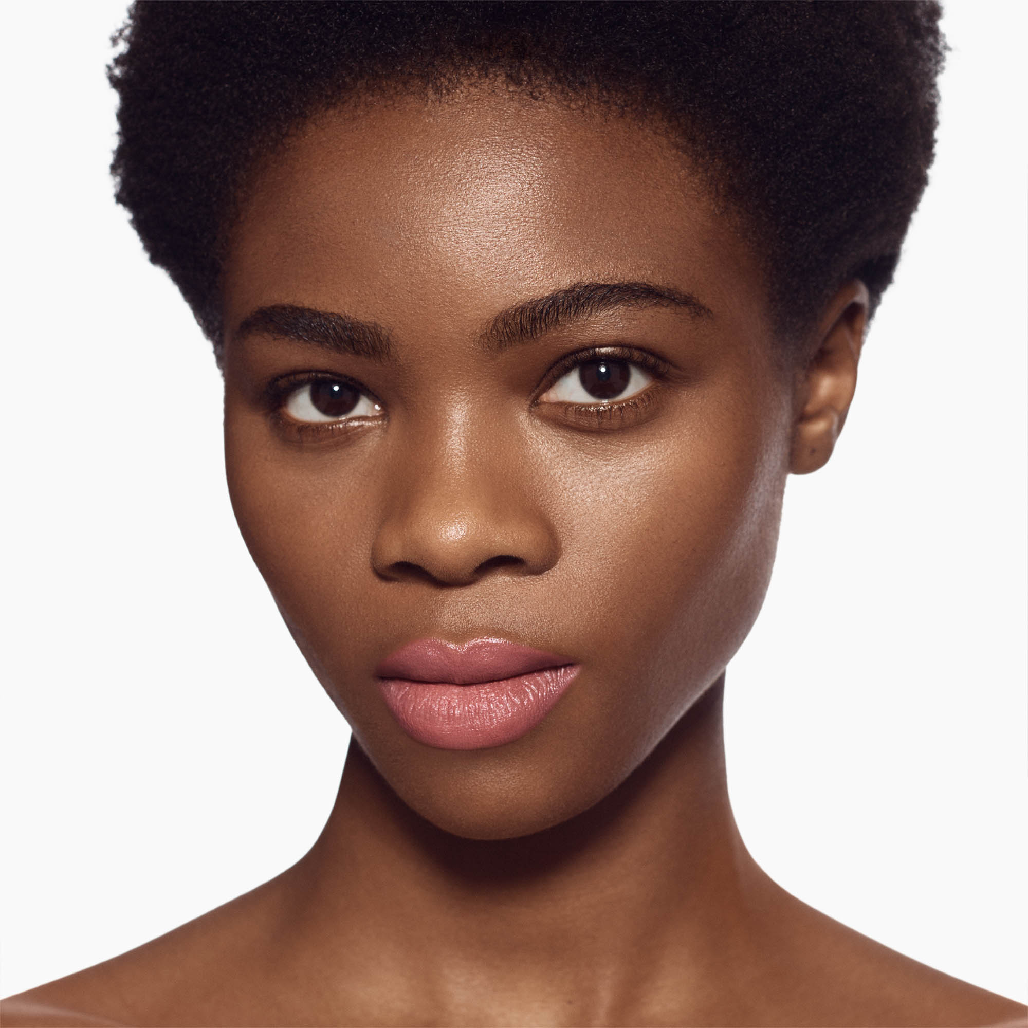Image of deep skin tone model wearing the Satin Lip Color Rich Refillable Lipstick in shade Demure 1