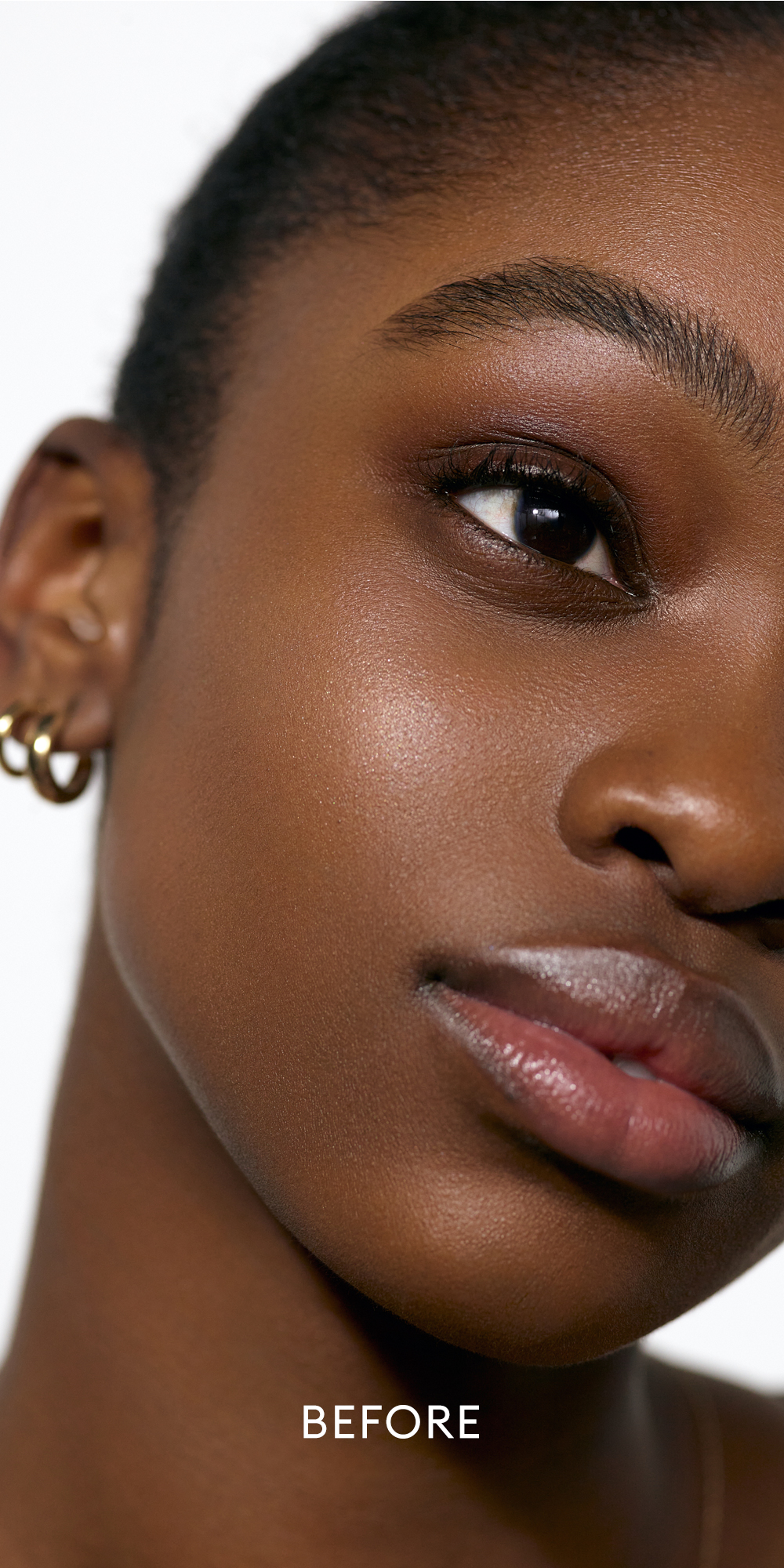 Before image of deep skin tone model wearing the Solar Radiance Hydrating Cream Highlight in shade Prismatic 1
