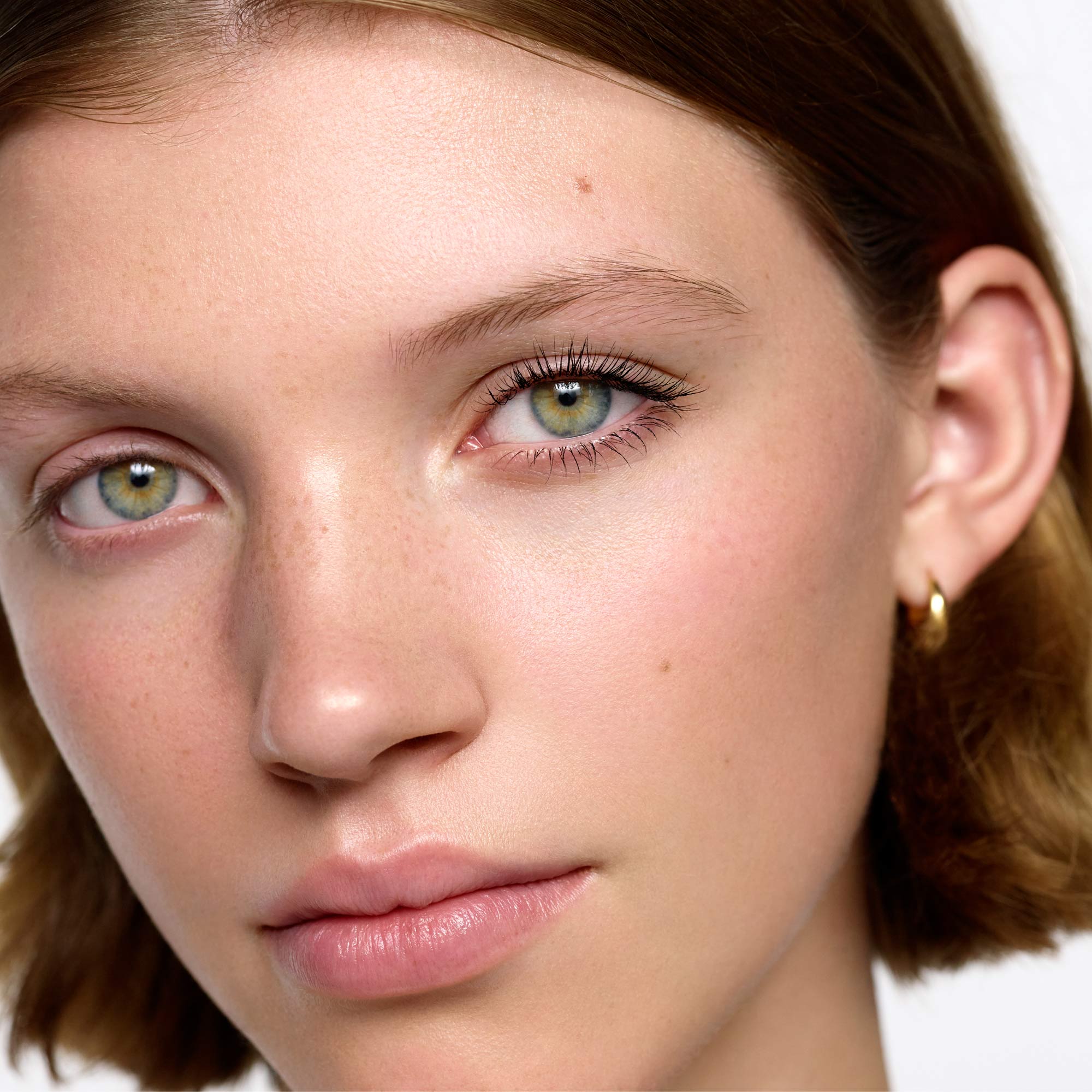 Image of medium skin tone model with fine lashes wearing the Ultra Black Lash Lift Serum Mascara