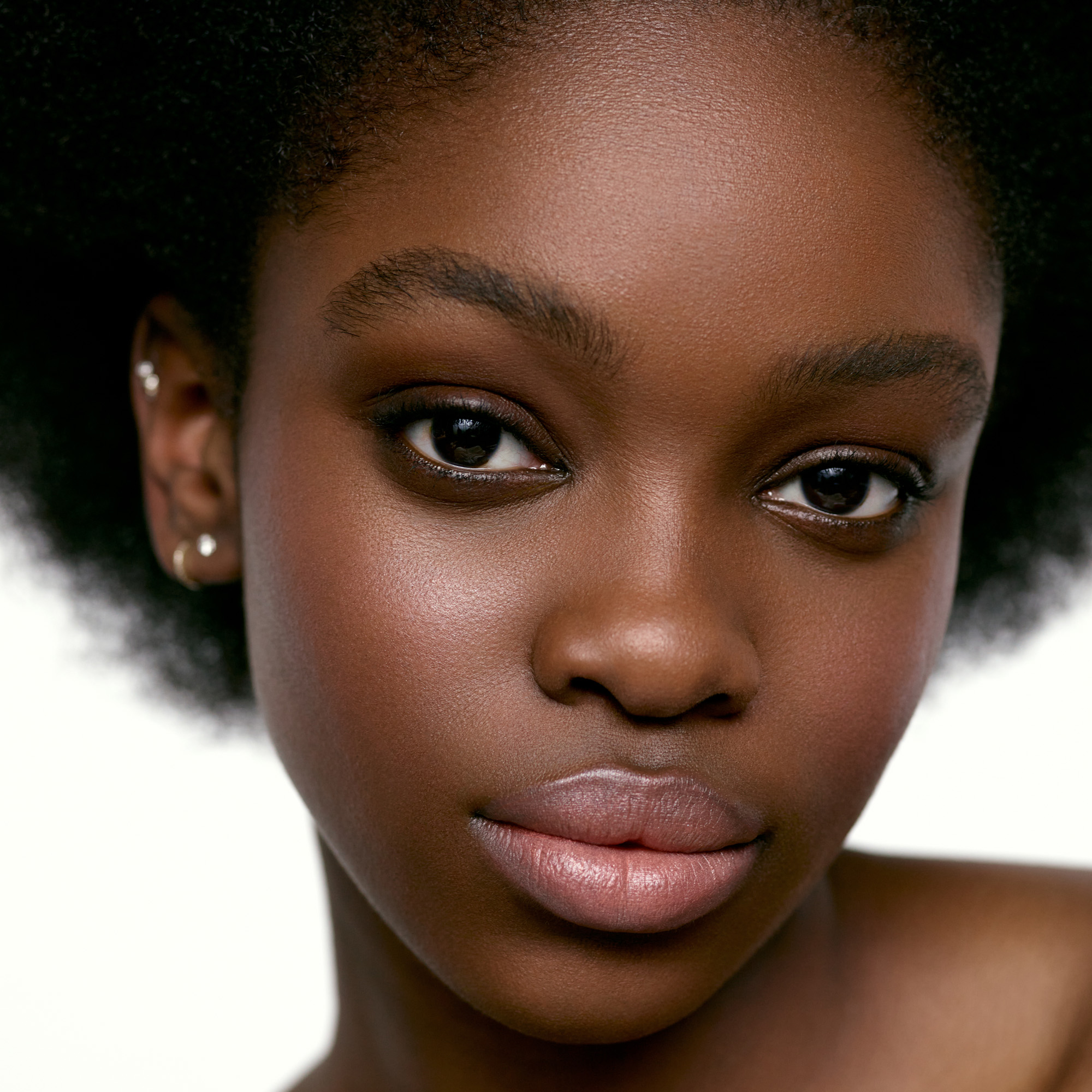 Image of a deep skin tone model wearing the Cream Blush Refillable Cheek & Lip Color in Hydrangea