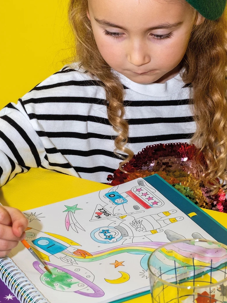 young girl drawing with floss and rock arts and crafts