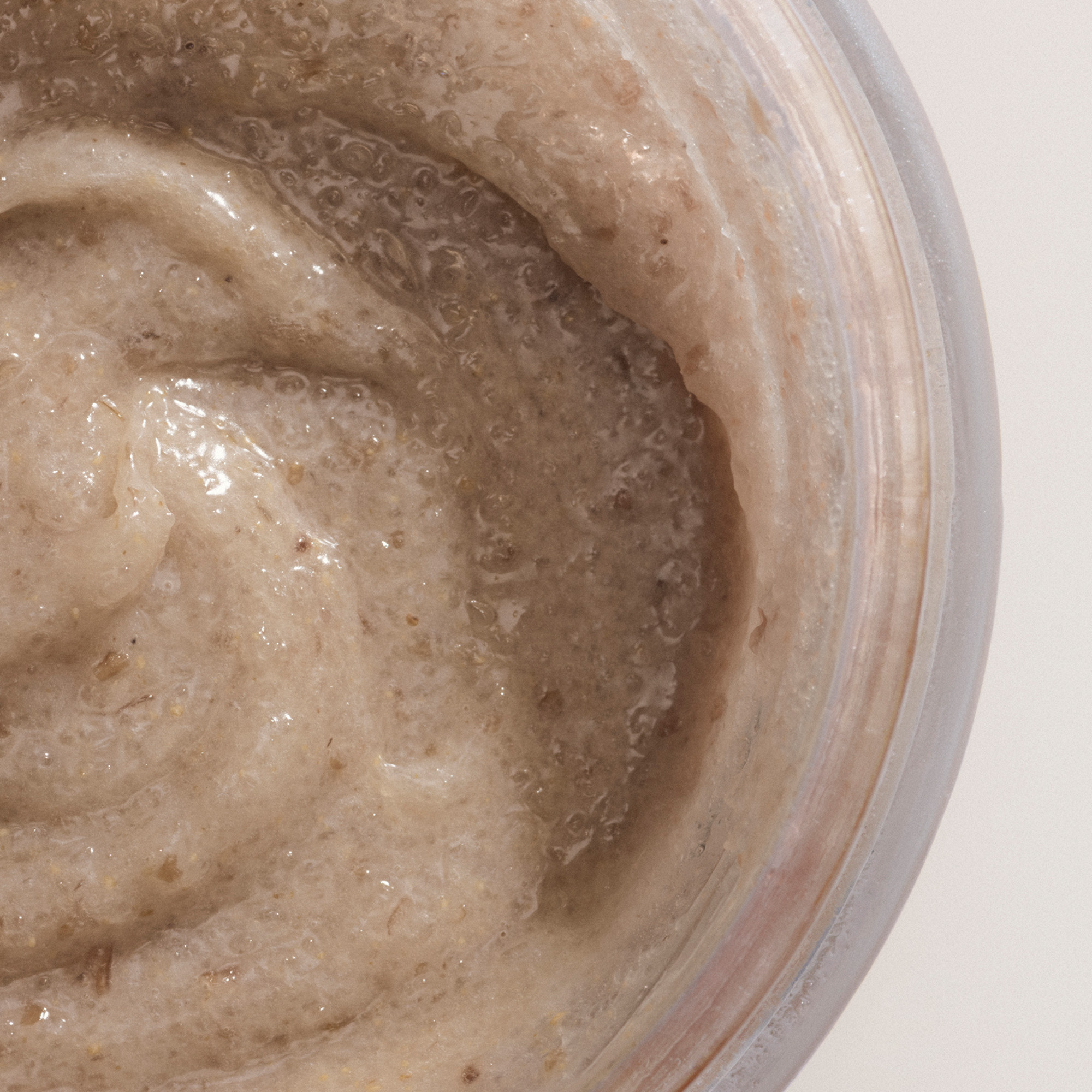 Macro shot of the Resurfacing & Balancing Body Polish inside the recyclable jar packaging.