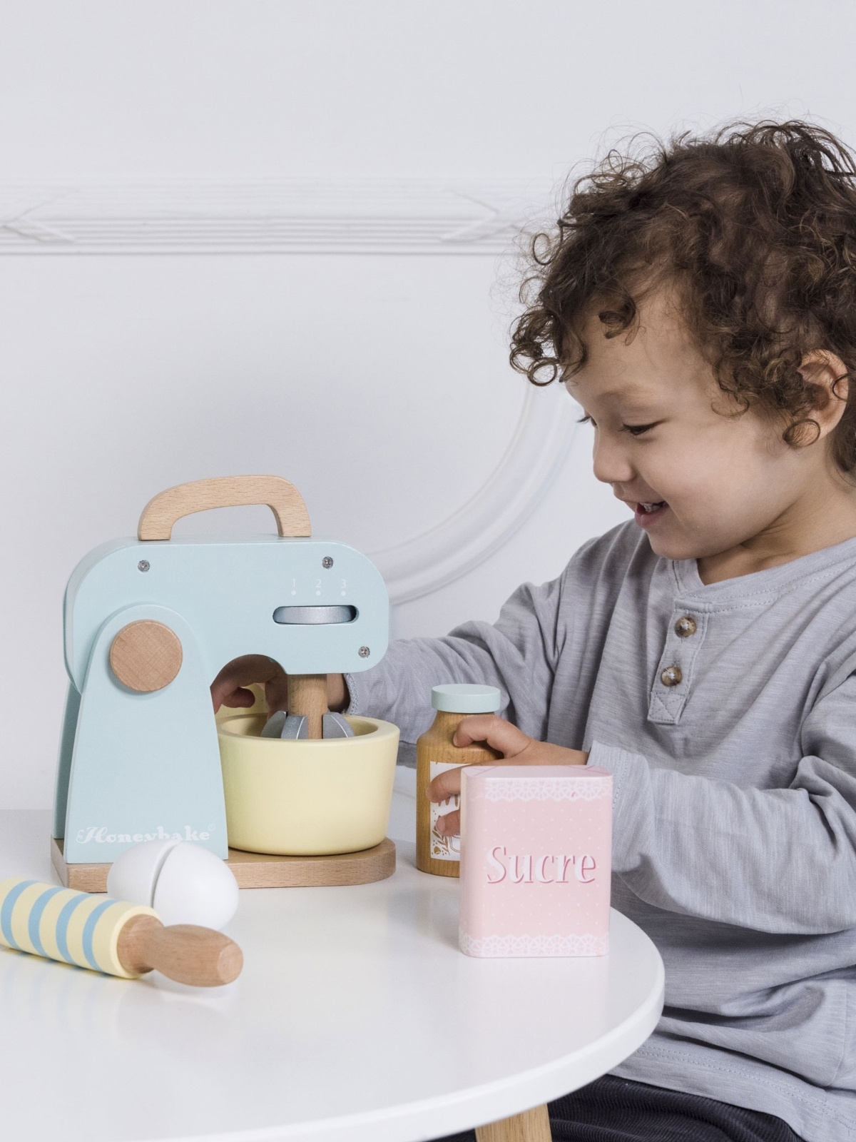 young boy playing with pretend toy mixer