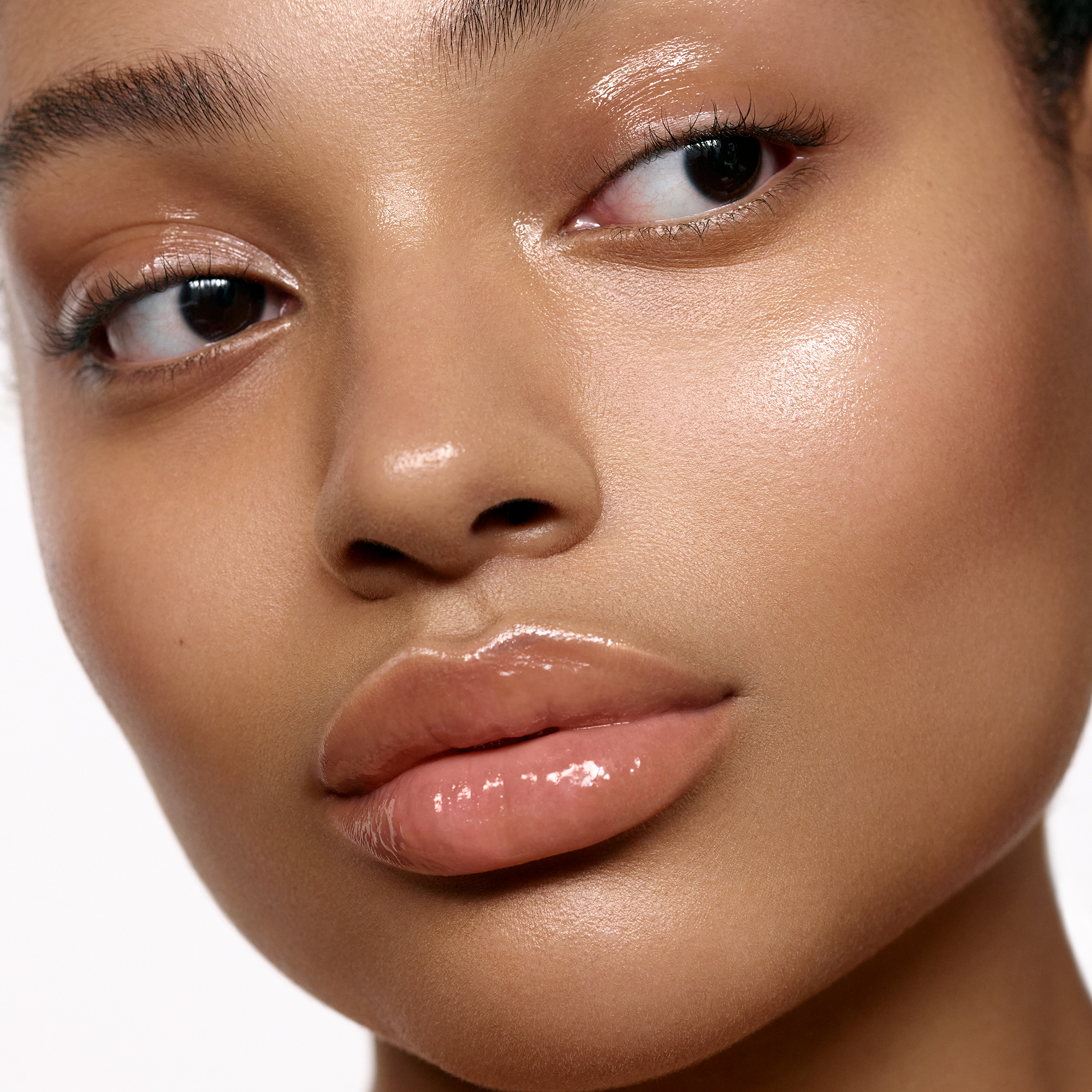 Deep skin tone model wearing lip treatment balm.