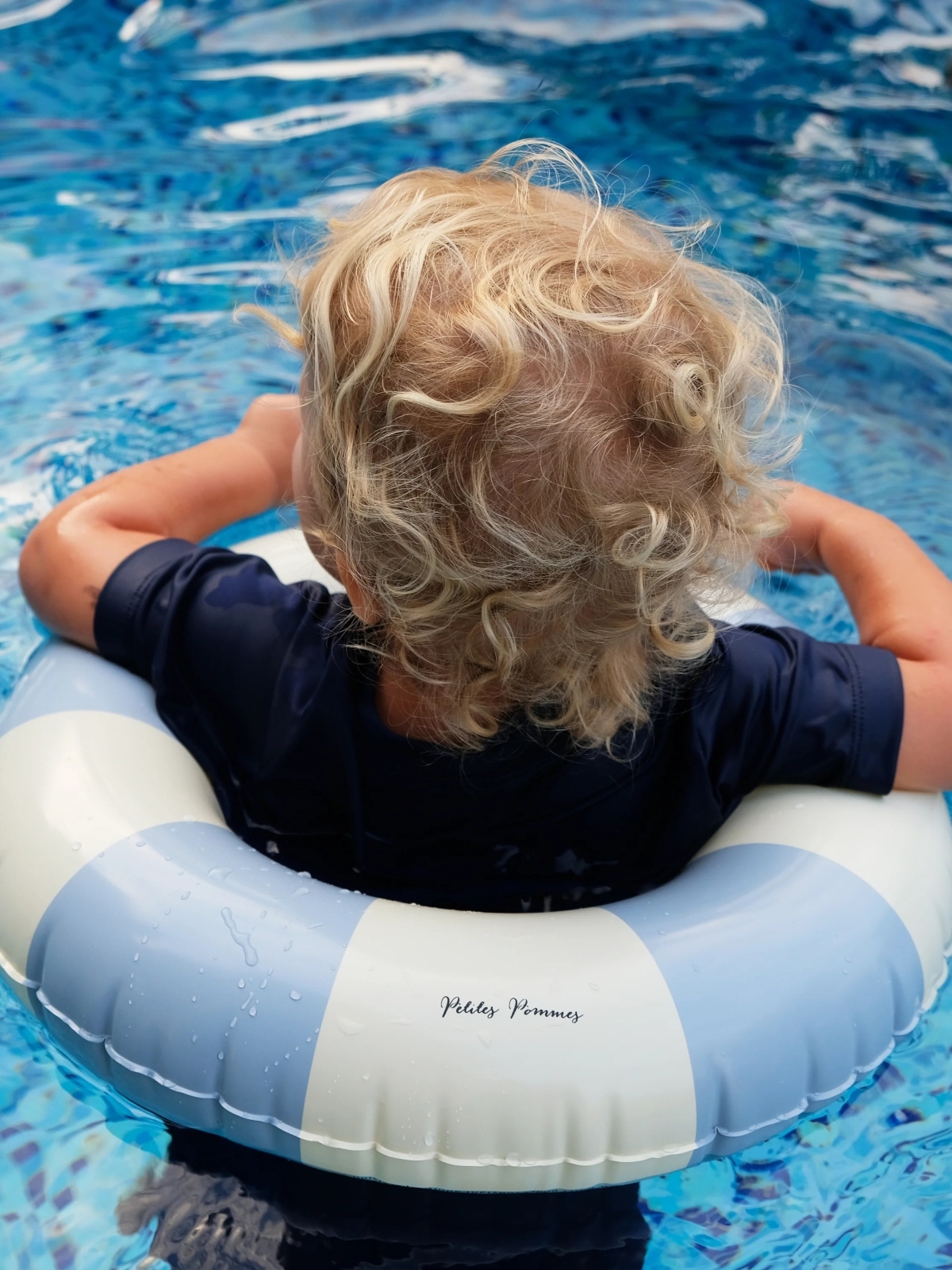 boy in blue swim ring in pool