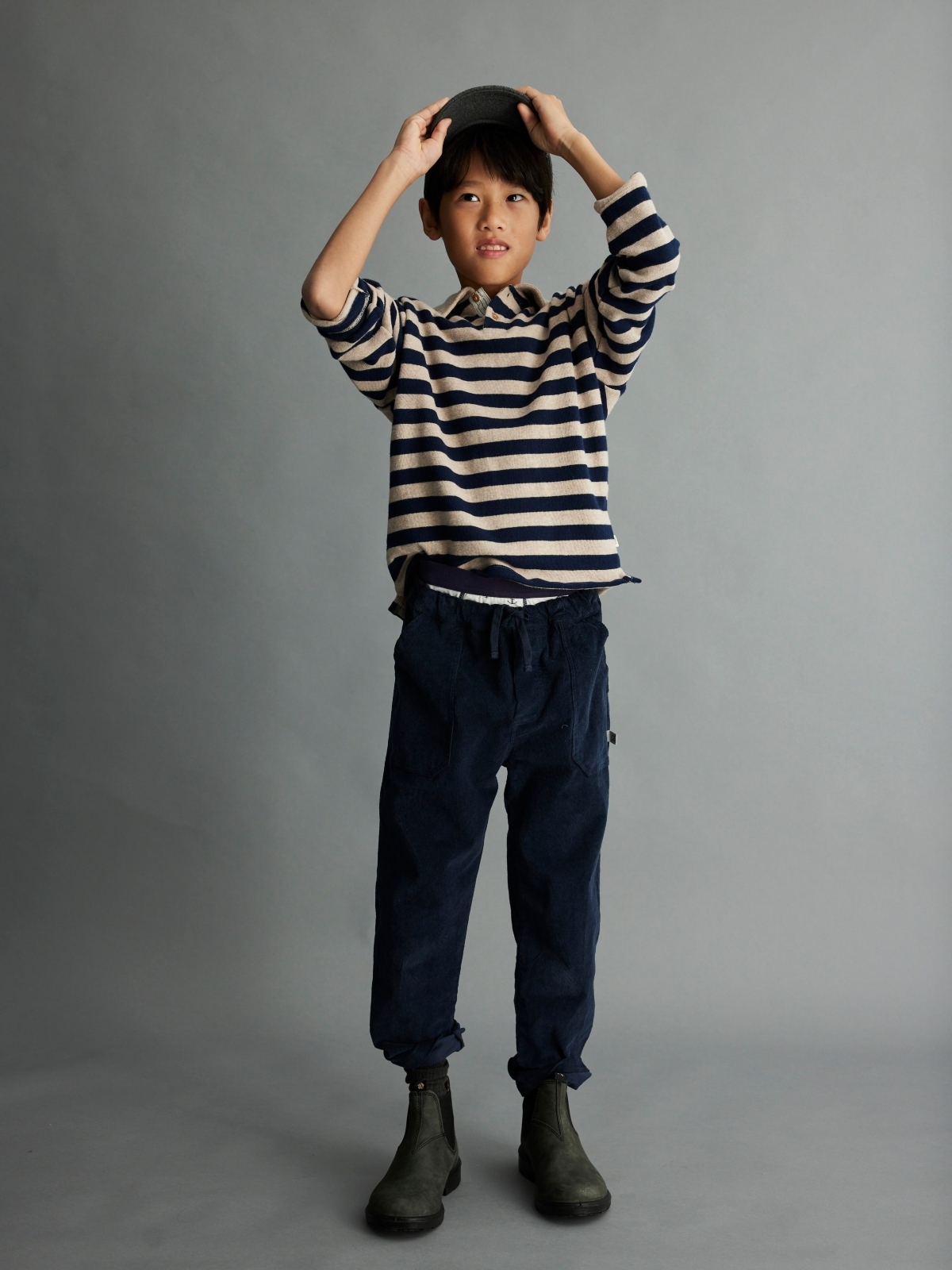 young boy wearing collared stripe shirt and corduroy pants
