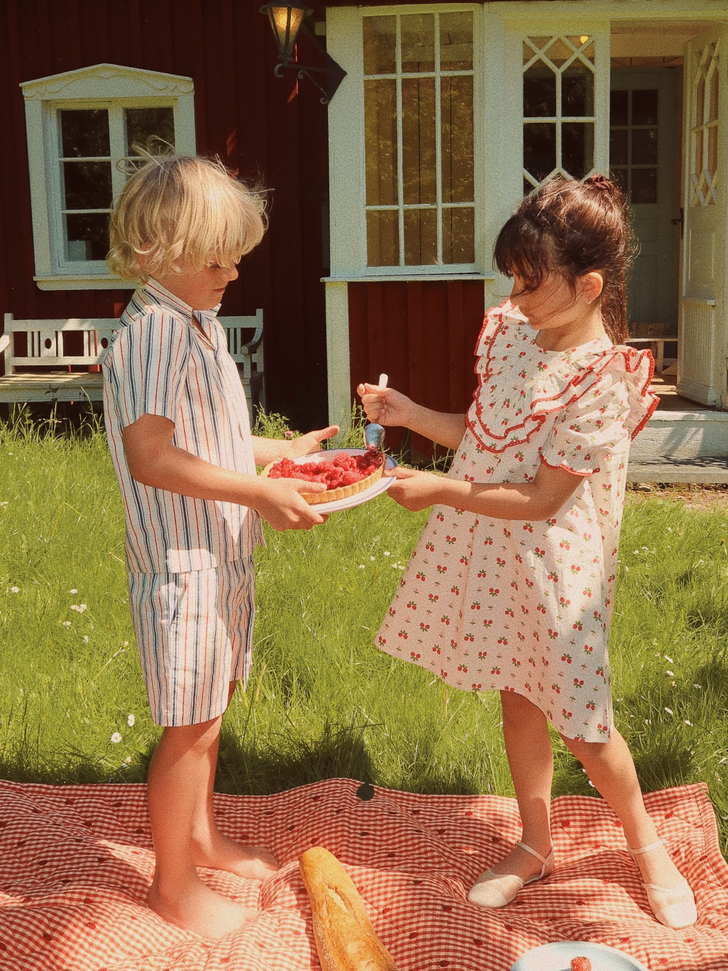boy and girl sharing a pie on picnic blanket