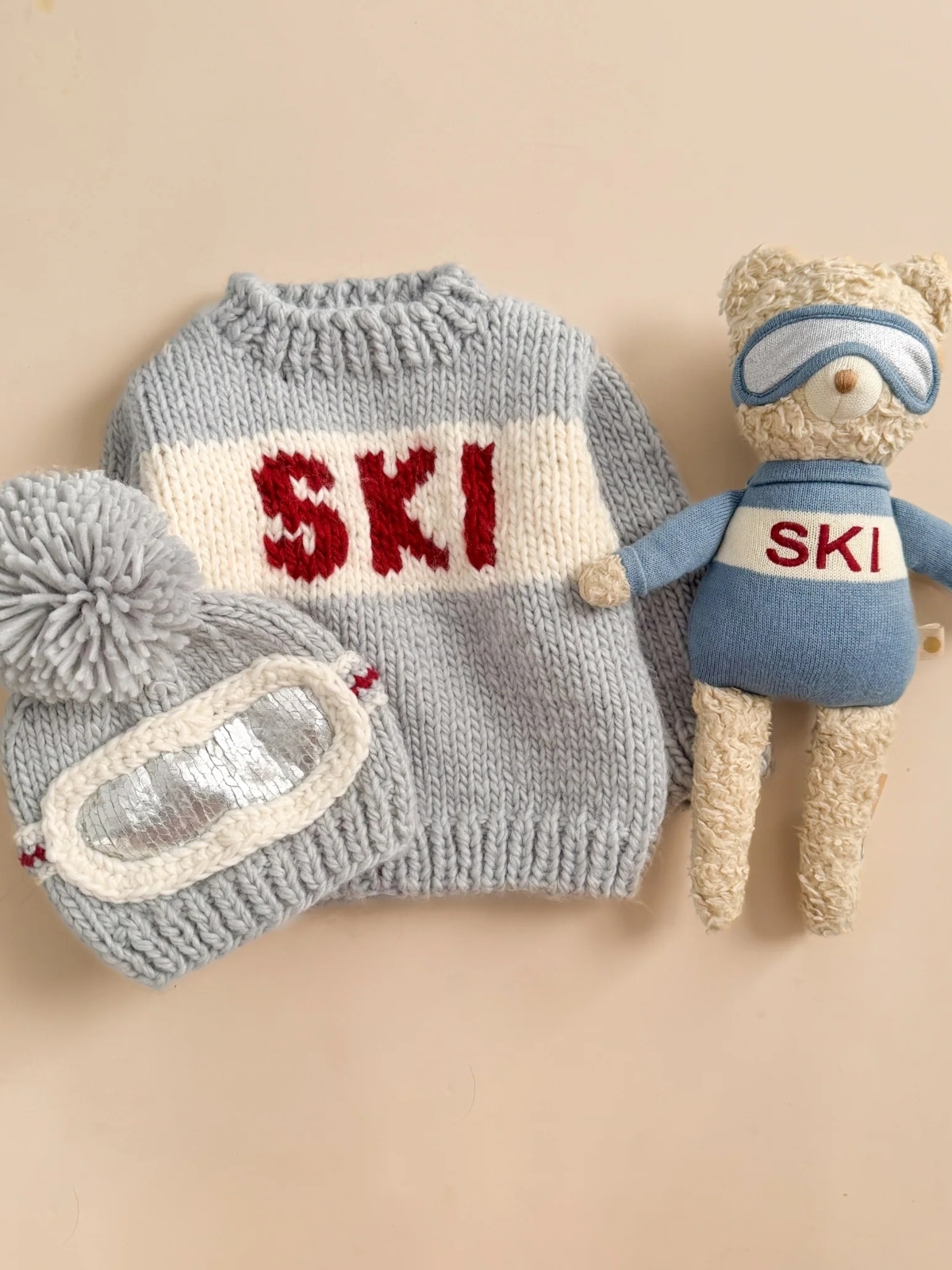 bear plush wearing sweater that says ski, sweater, and hat