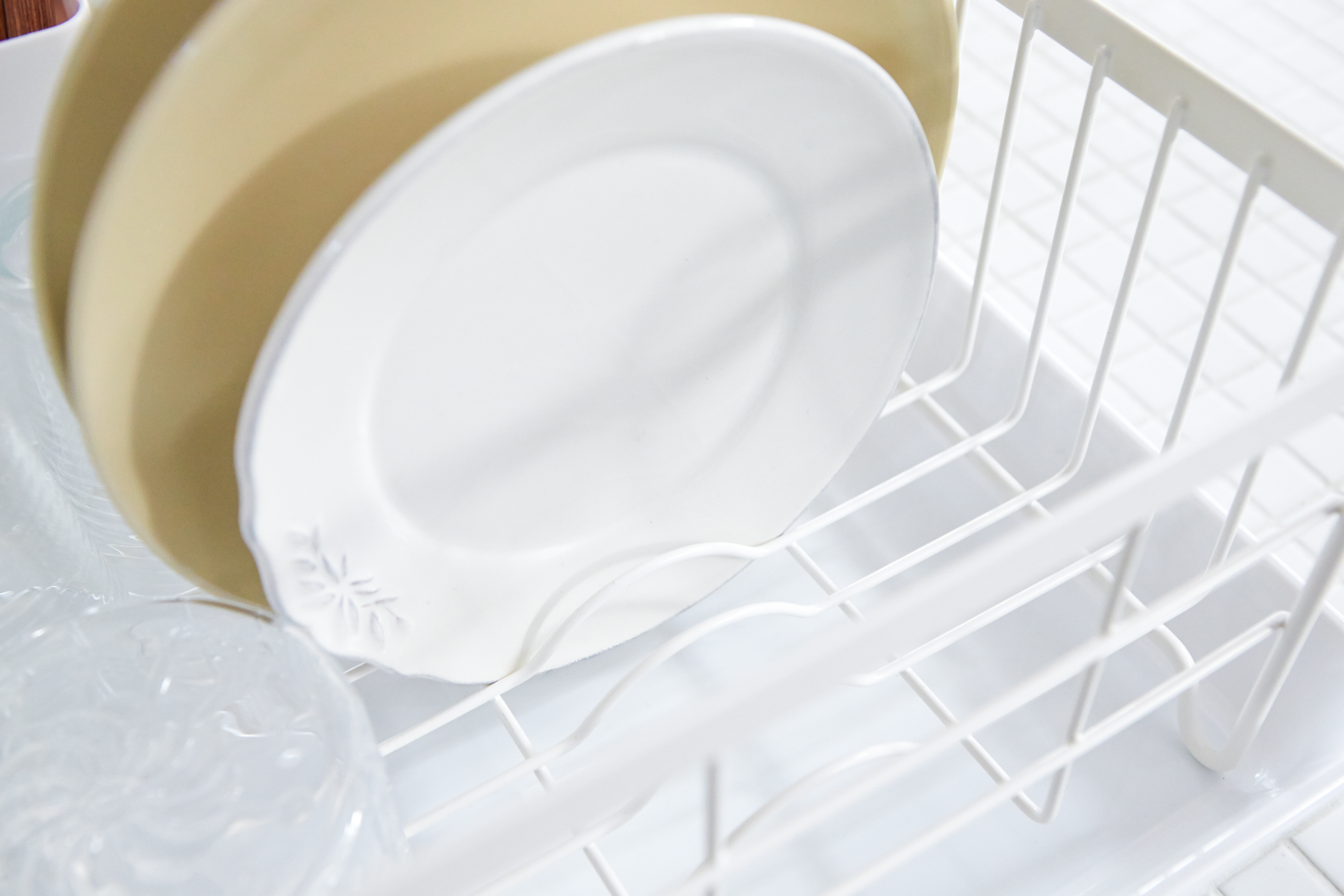Close up aerial view of white Dish Rack holding plates and cups by Yamazaki Home.