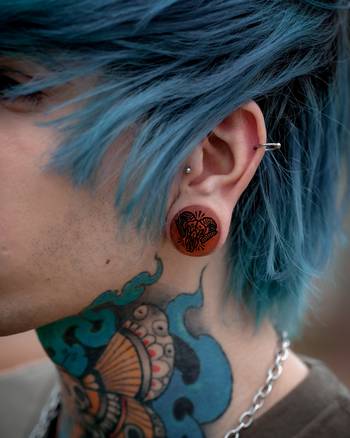 Alternative Tattooed man wearing custom made Sacrificial Lamb Plug / Gauge - Saba Wood | Flat Faced Double Flare