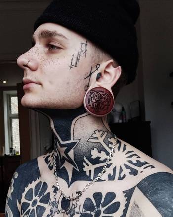 Alternative Tattooed man wearing custom made Sacrificial Lamb Plug / Gauge - Saba Wood | Flat Faced Double Flare