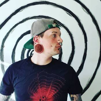 Alternative Tattooed man wearing custom made Sacrificial Lamb Plug / Gauge - Saba Wood | Flat Faced Double Flare