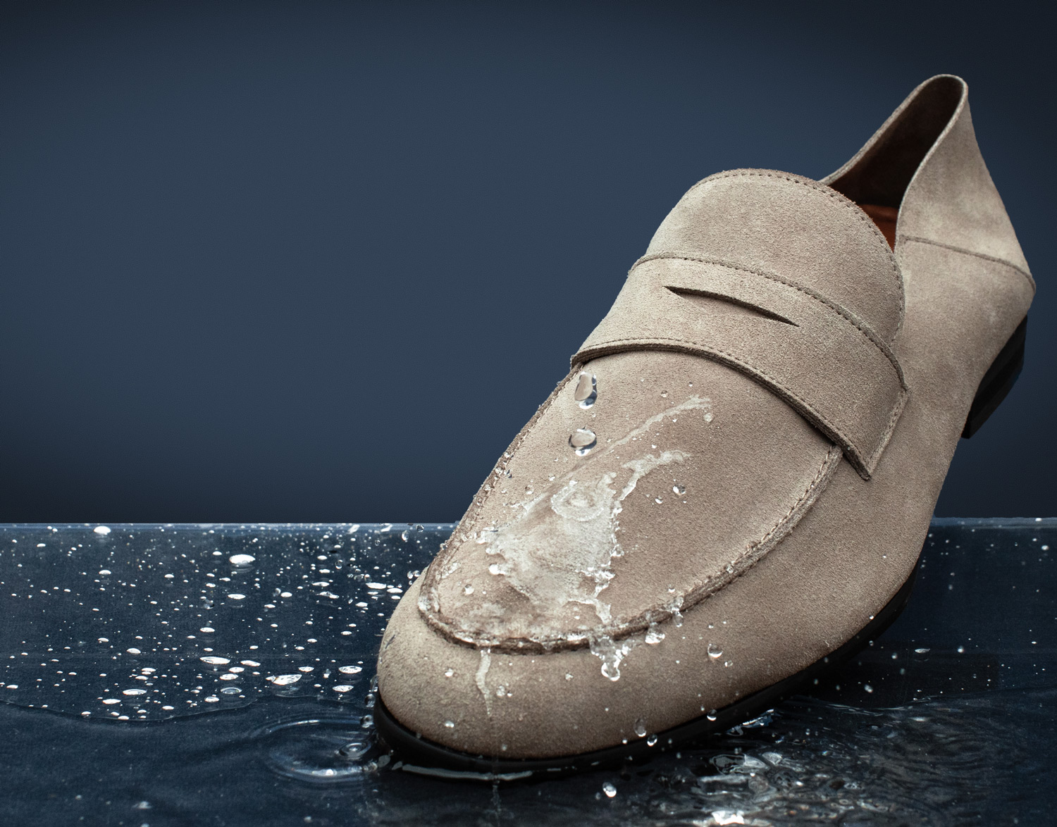 Close up view of water drops repelling off of dress shoe Monaco Loafer in Coast Gray