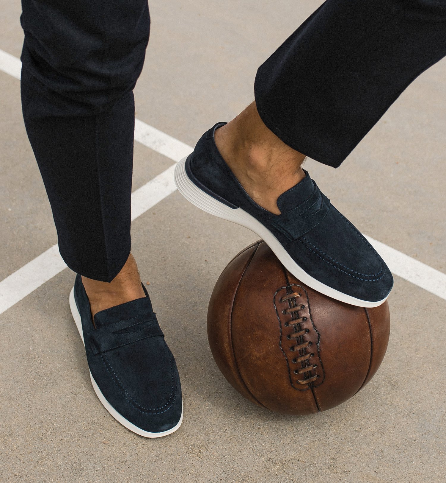 Knee down view of man kicking a basketball wearing Hybrid Dress shoe Crossover Loafer in Navy