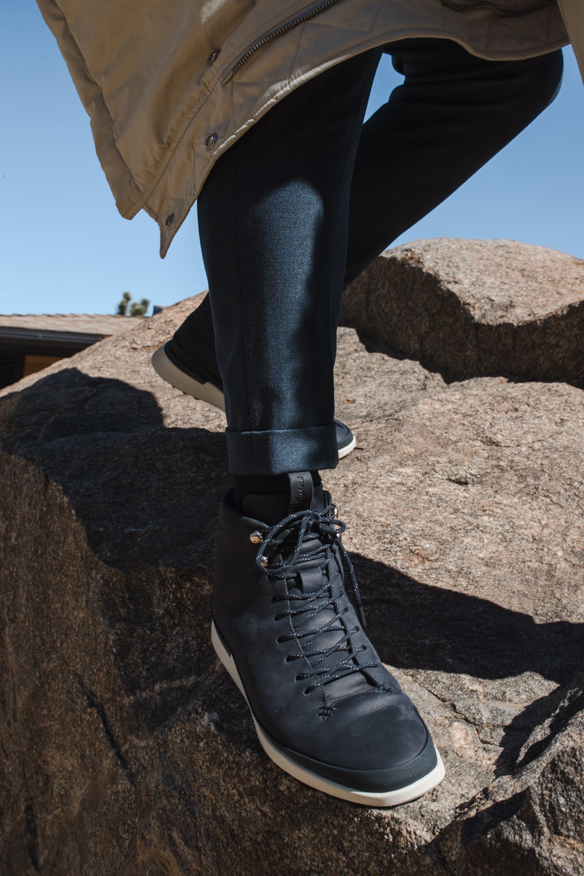 Knee down view of a man climbing a rock wearing Men's boot Crossover Hiker WTZ in Navy