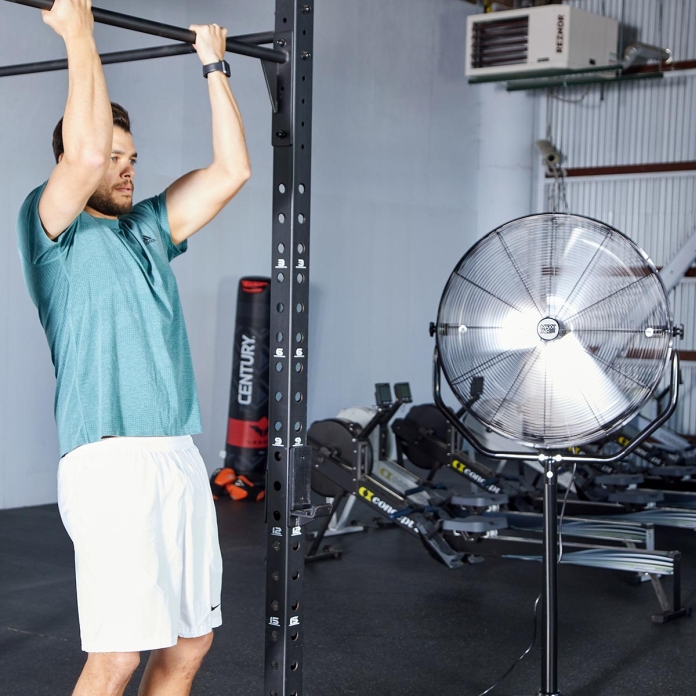A 30 in. yoke pedestal fan cools an athlete during a workout.