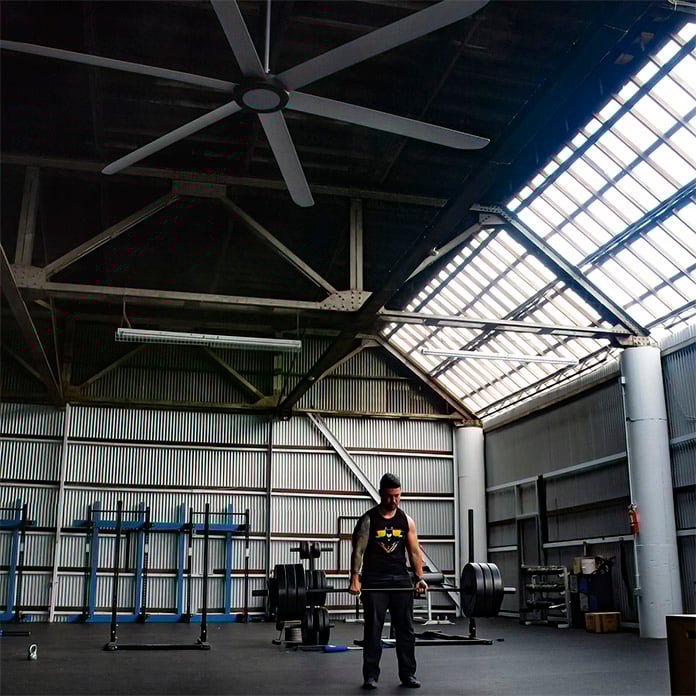 An HVLS fan works in a large open gym to cool athletes.