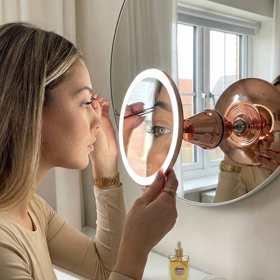 Woman using the lana 10x magnifying mirror to apply eyeshadow