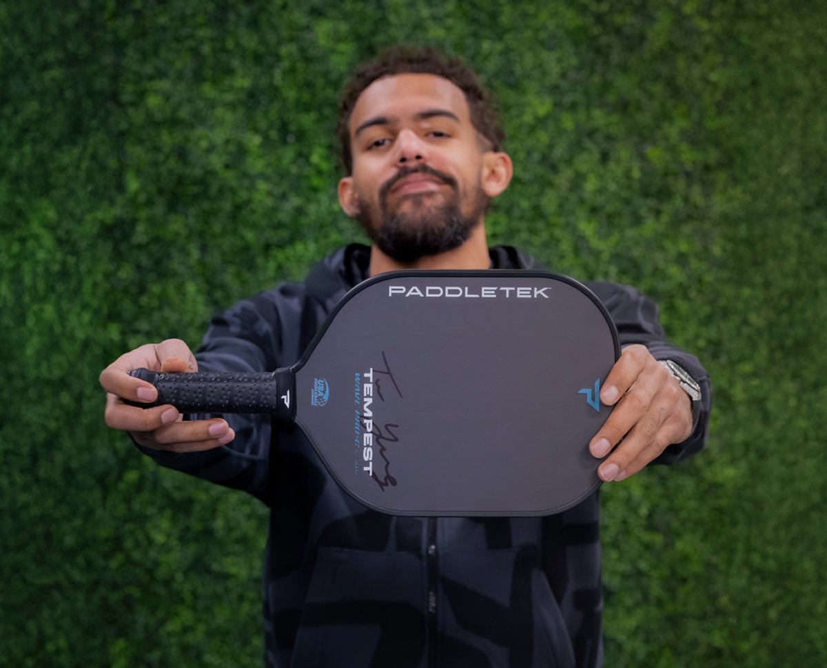 Trae Young holding his signature Tempest Wave Pro-C 12.7 paddle from Paddletek