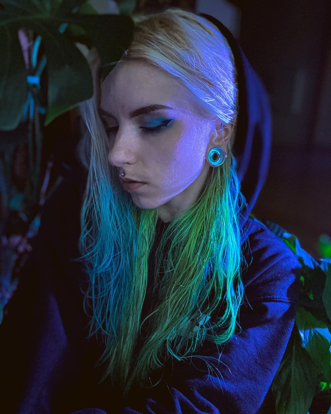 Girl wearing bright  Blue & Green Iridescent Glass Ear Tunnel