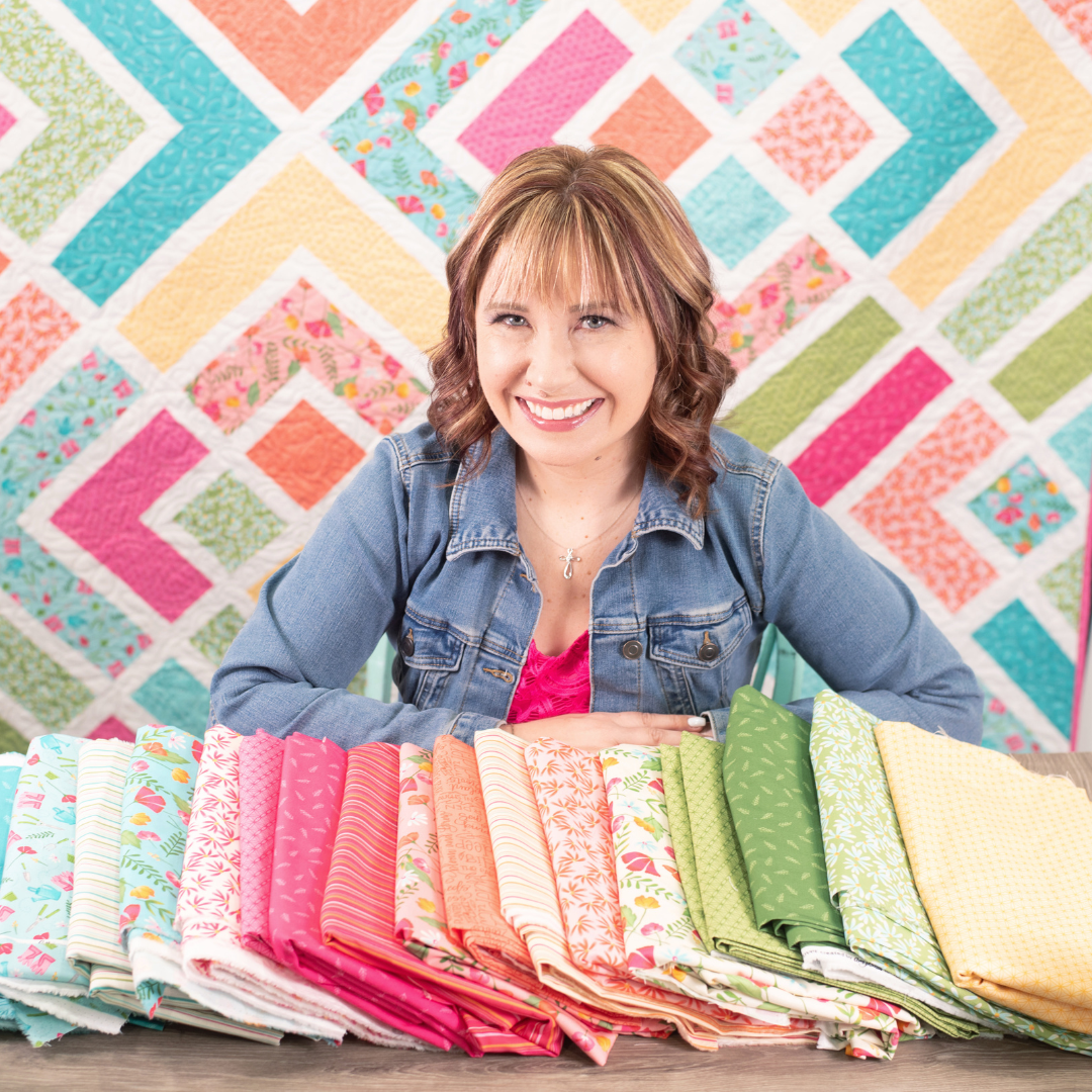 Amy Latta poses with a colorful selection of quilt fabrics from her fabric collections with Andover.