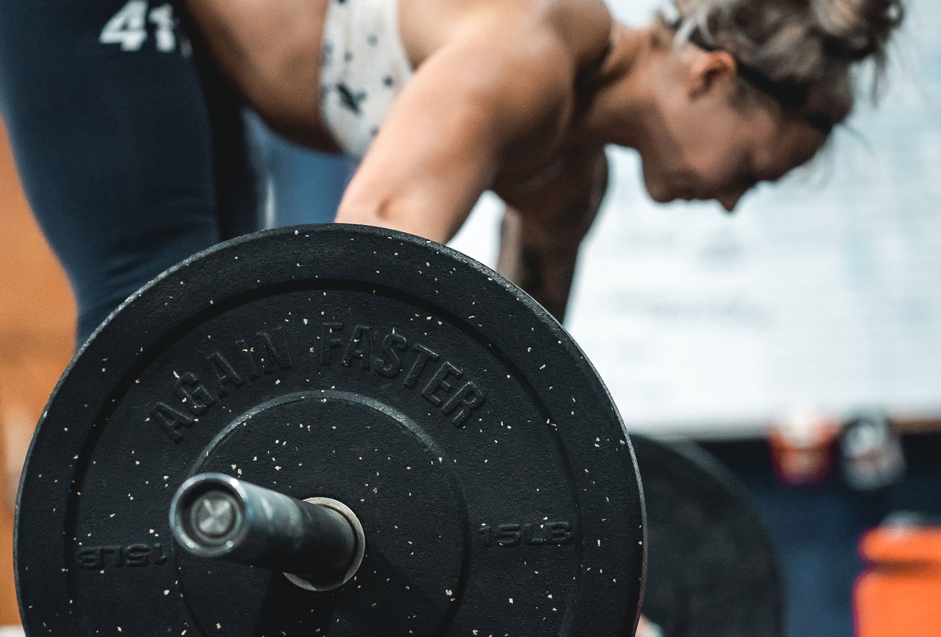 woman deadlifting olympic weights