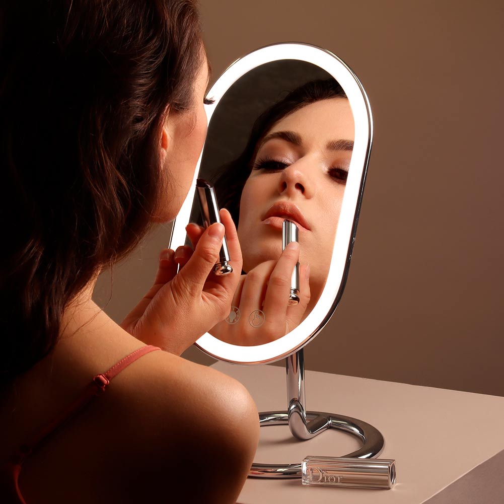 Woman using the Vera vanity mirror in black to apply skincare