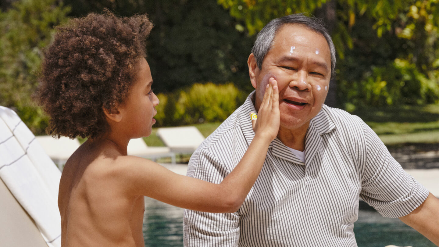 Kid applying grandpa pipette mineral sunscreen SPF.