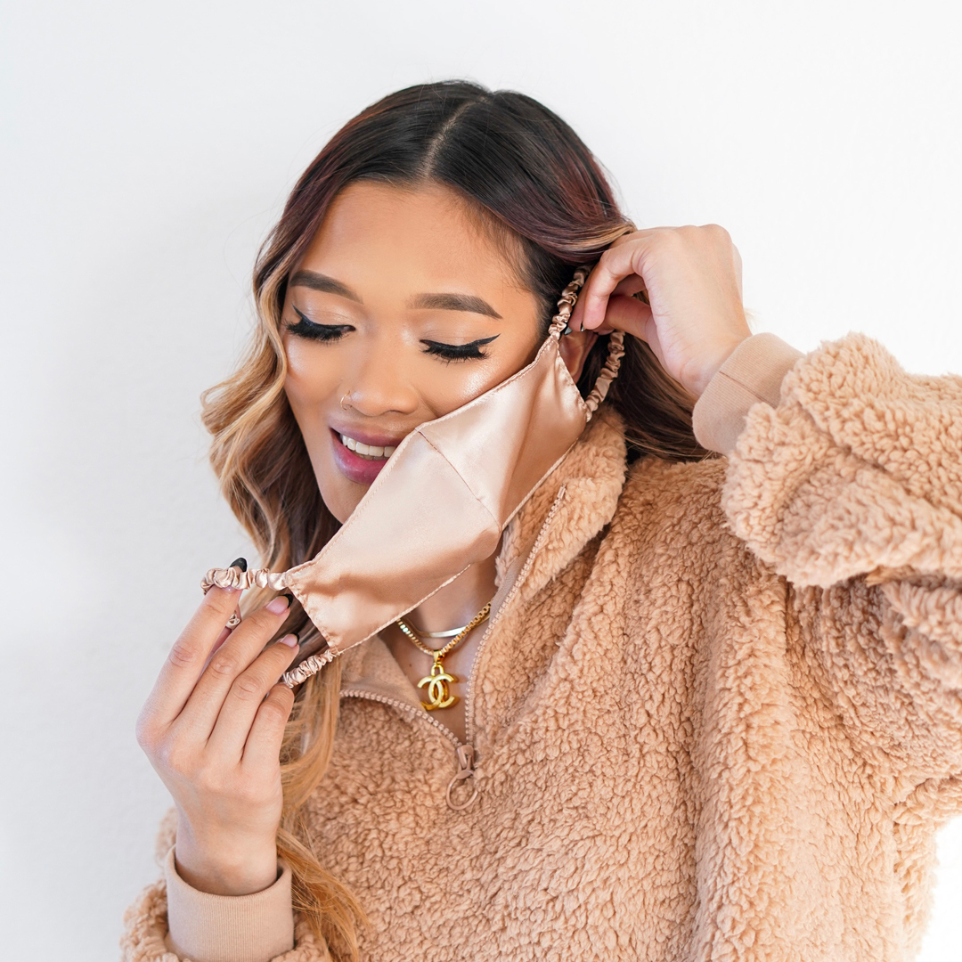 Woman putting on the Fancii reusable face mask in dusty rose